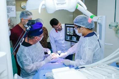 Equipe em cirurgia de implante com monitor 3D